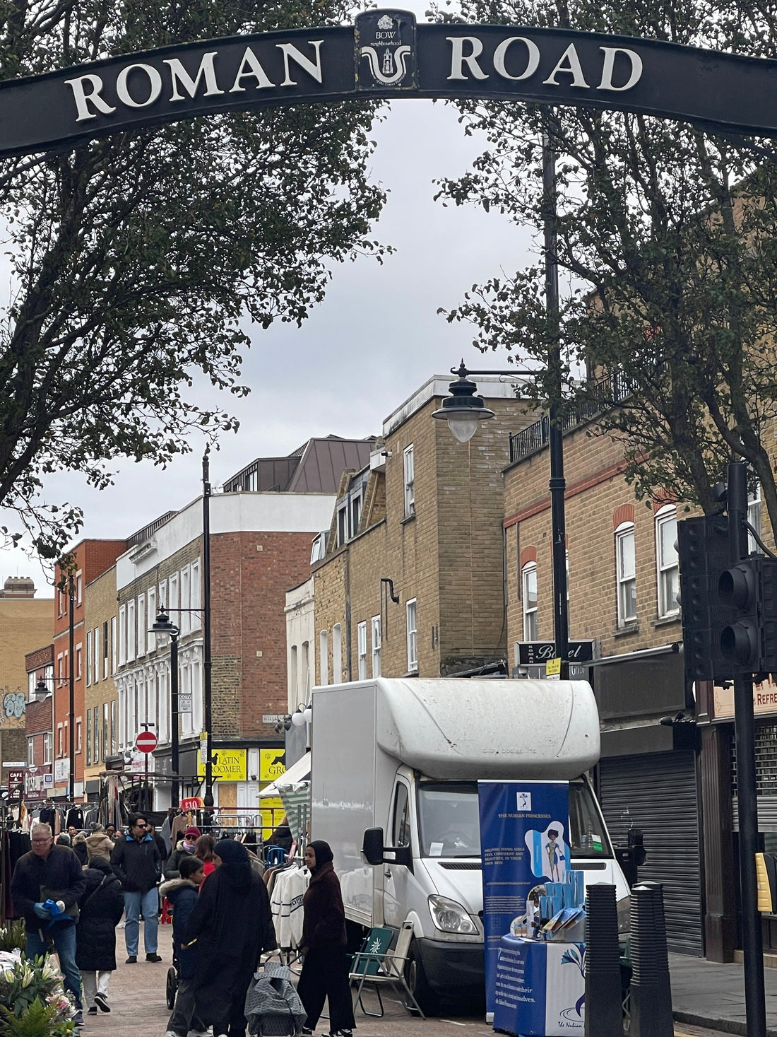 The Roman Road Market archway in East London on a busy Saturday, showing the vibrant community setting where The Nubian Princesses stall was displayed, promoting cultural representation and positive identity through storytelling and play.